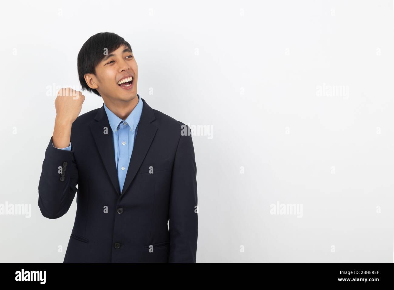 Excited young business Asian man raising his fists with happy delighted ...
