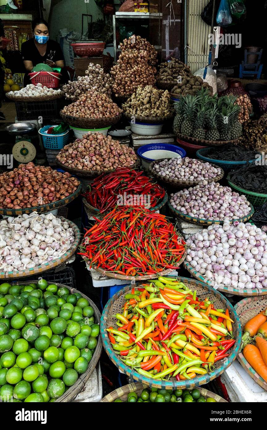Hanoi, Vietnam, Febuary 1, 2020 - Fresh vegetables for sale at street food market in the old town.  Garlic, Lemon, Ananas, Onions, Peper, Red chillies Stock Photo