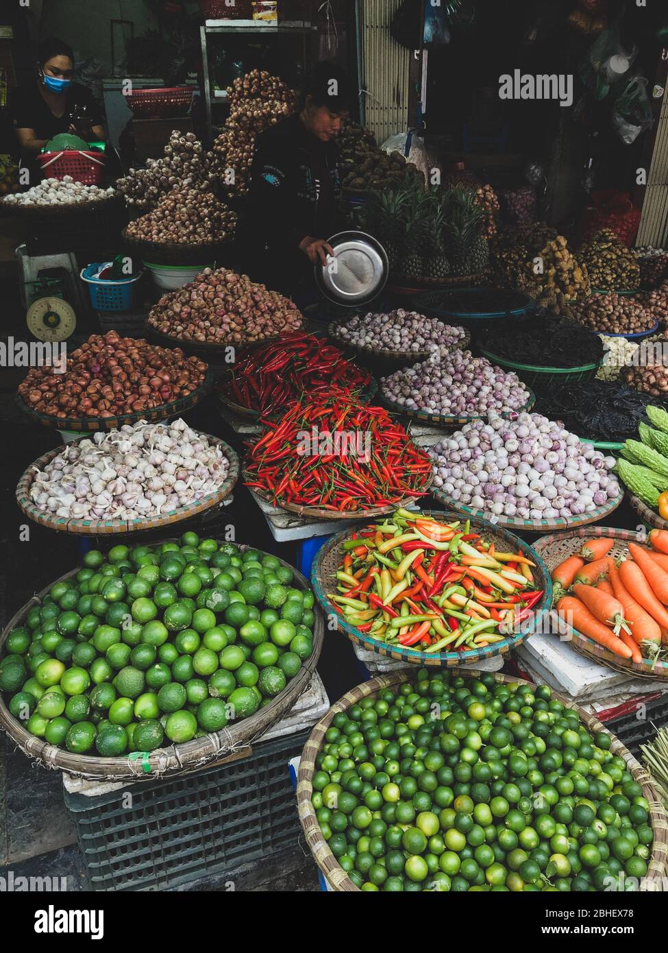 Hanoi, Vietnam, Febuary 1, 2020 - Fresh vegetables for sale at street food market in the old town.  Garlic, Lemon, Ananas, Onions, Peper, Red chillies Stock Photo