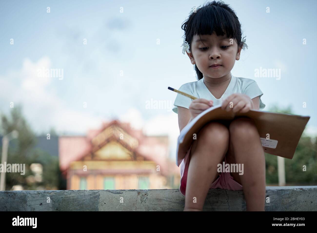 Little girl writing and studying at home, study from home during a coronavirus outbreak Stock Photo