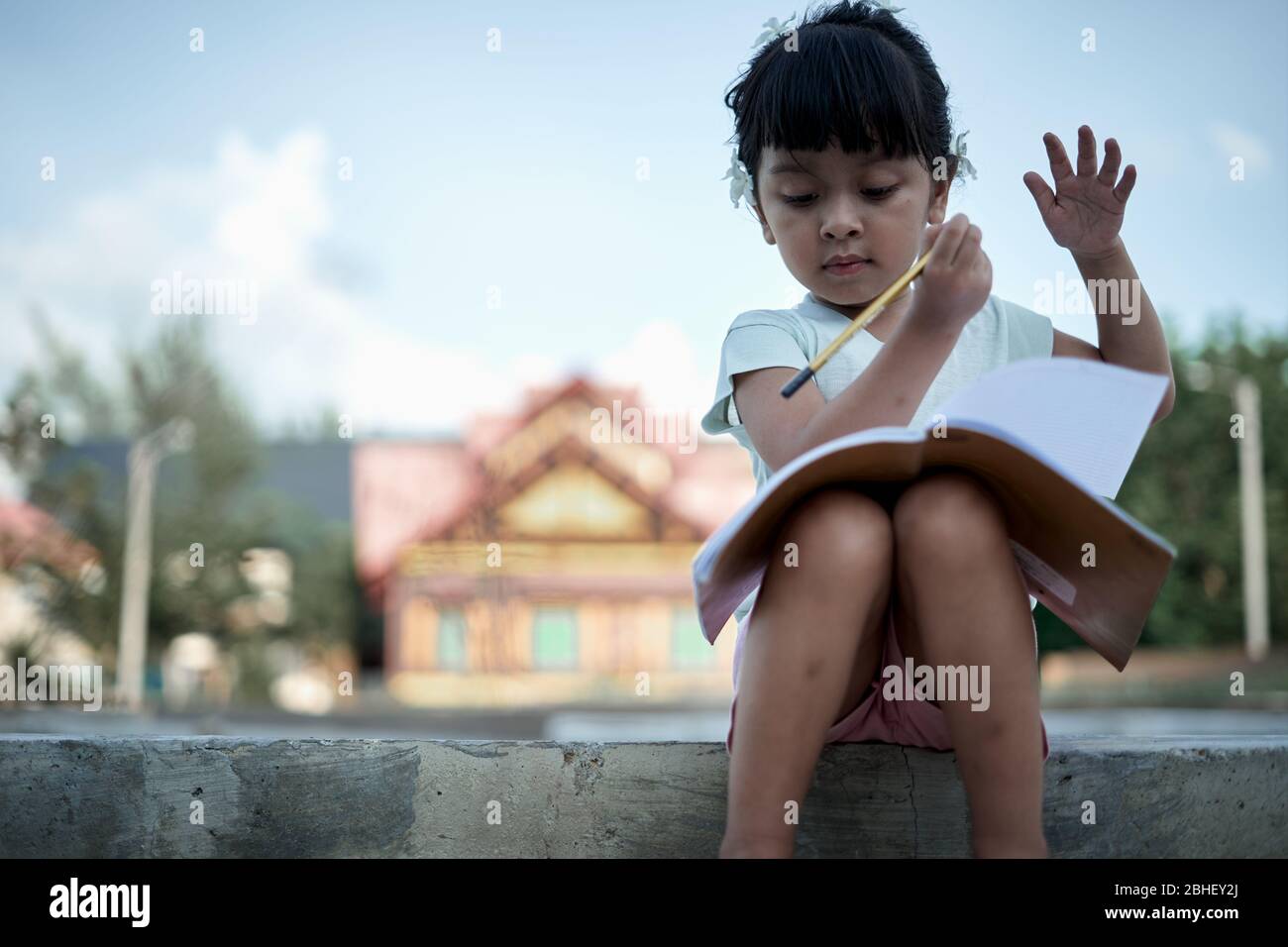 Little girl writing and studying at home, study from home during a coronavirus outbreak Stock Photo