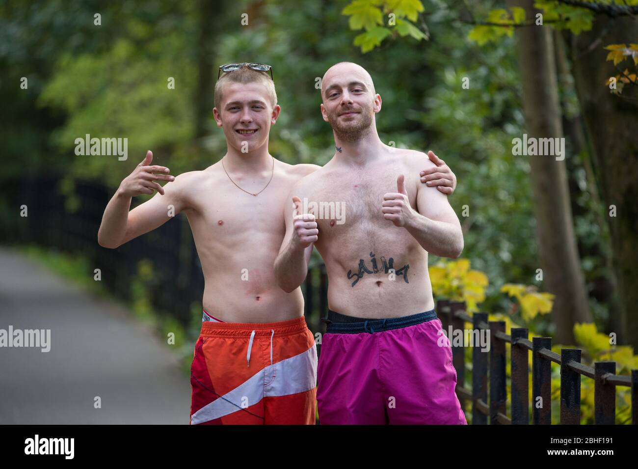 Glasgow, UK. 25th Apr, 2020. Pictured: (left-right) Keiran Macginley & Keir Fox, enjoying the sunshine in the park. As the saying goes in Glasgow if the sun is out it's “taps aff” weather. Scenes from the first weekend of the extended lockdown from KelvinGrove Park in Glasgow's West End during a very hot and sunny Saturday. Credit: Colin Fisher/Alamy Live News Stock Photo