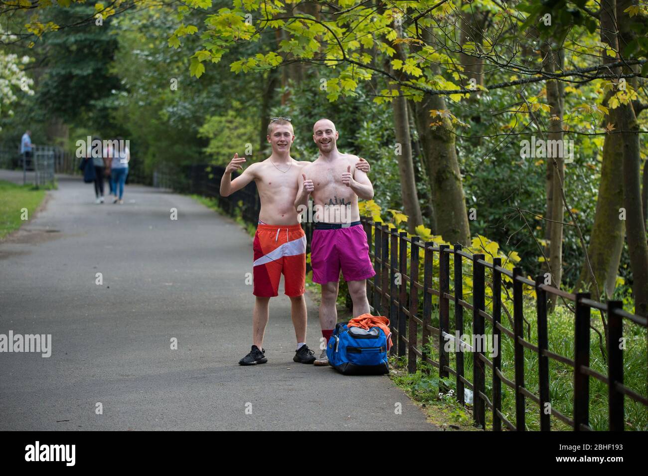Glasgow, UK. 25th Apr, 2020. Pictured: (left-right) Keiran Macginley & Keir Fox, enjoying the sunshine in the park. As the saying goes in Glasgow if the sun is out it's “taps aff” weather. Scenes from the first weekend of the extended lockdown from KelvinGrove Park in Glasgow's West End during a very hot and sunny Saturday. Credit: Colin Fisher/Alamy Live News Stock Photo