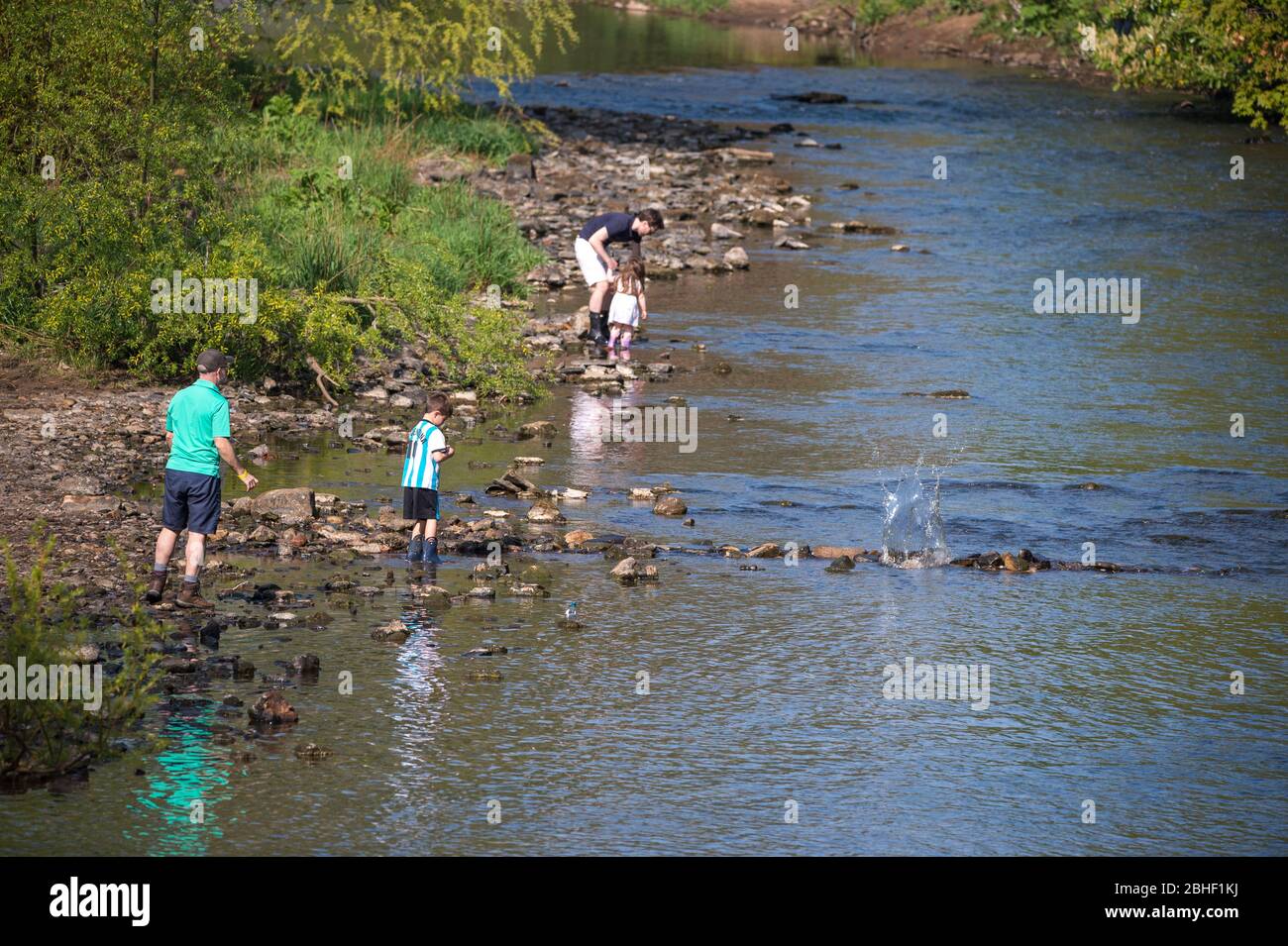 Glasgow, UK. 25th Apr, 2020. Pictured: People seen playing in the water of the River Kelvin which meanders through the edge of Kelvingrove Park. Scenes from the first weekend of the extended lockdown from KelvinGrove Park in Glasgow's West End during a very hot and sunny Saturday. Credit: Colin Fisher/Alamy Live News Stock Photo
