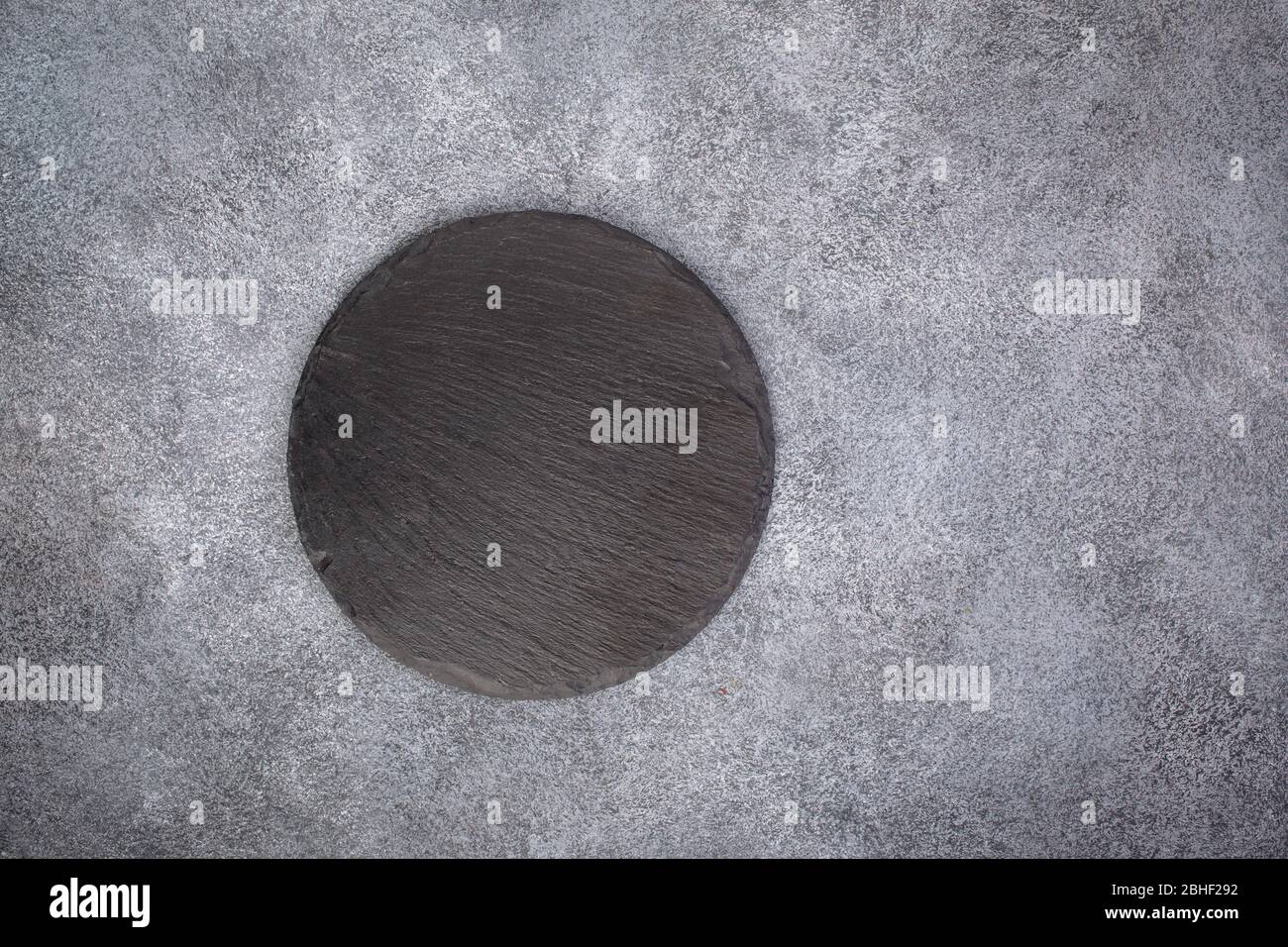 Empty slate round platter on gray Stock Photo