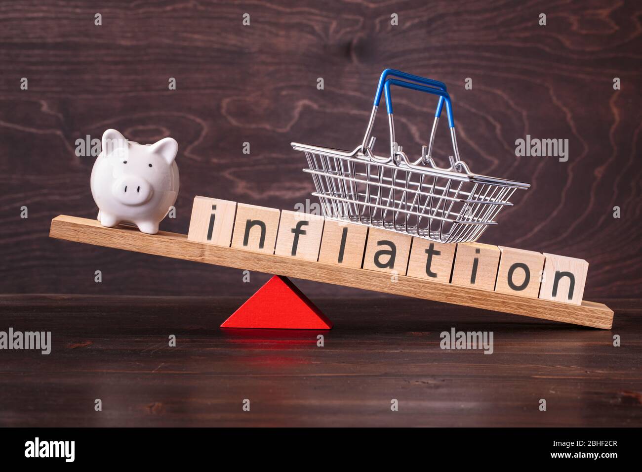 Inflation and piggy bank on seesaw Stock Photo