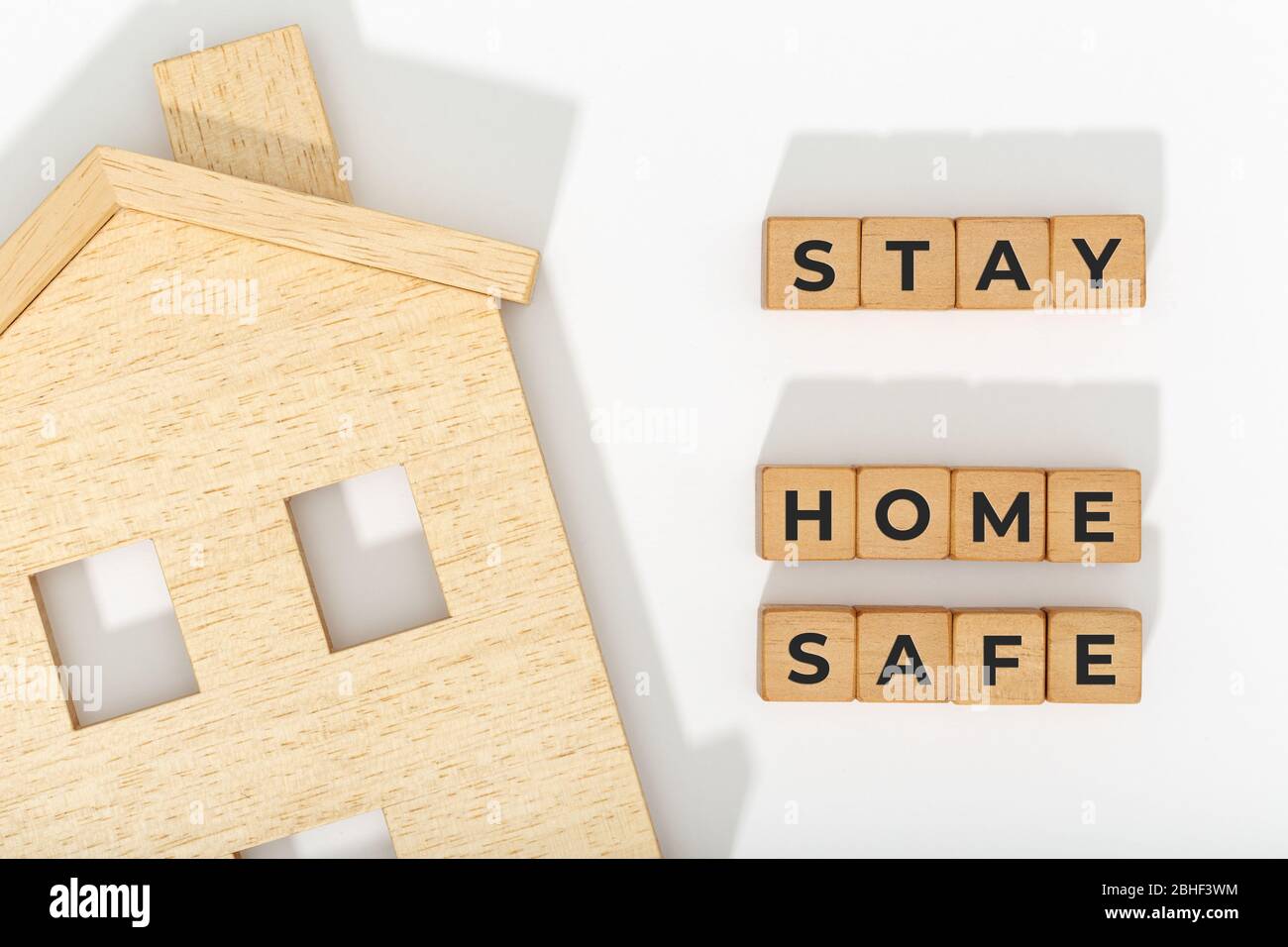 Stay at home stay safe concept. Coronavirus COVID-19 outbreak advice. Home icon and wooden blocks on white background Stock Photo