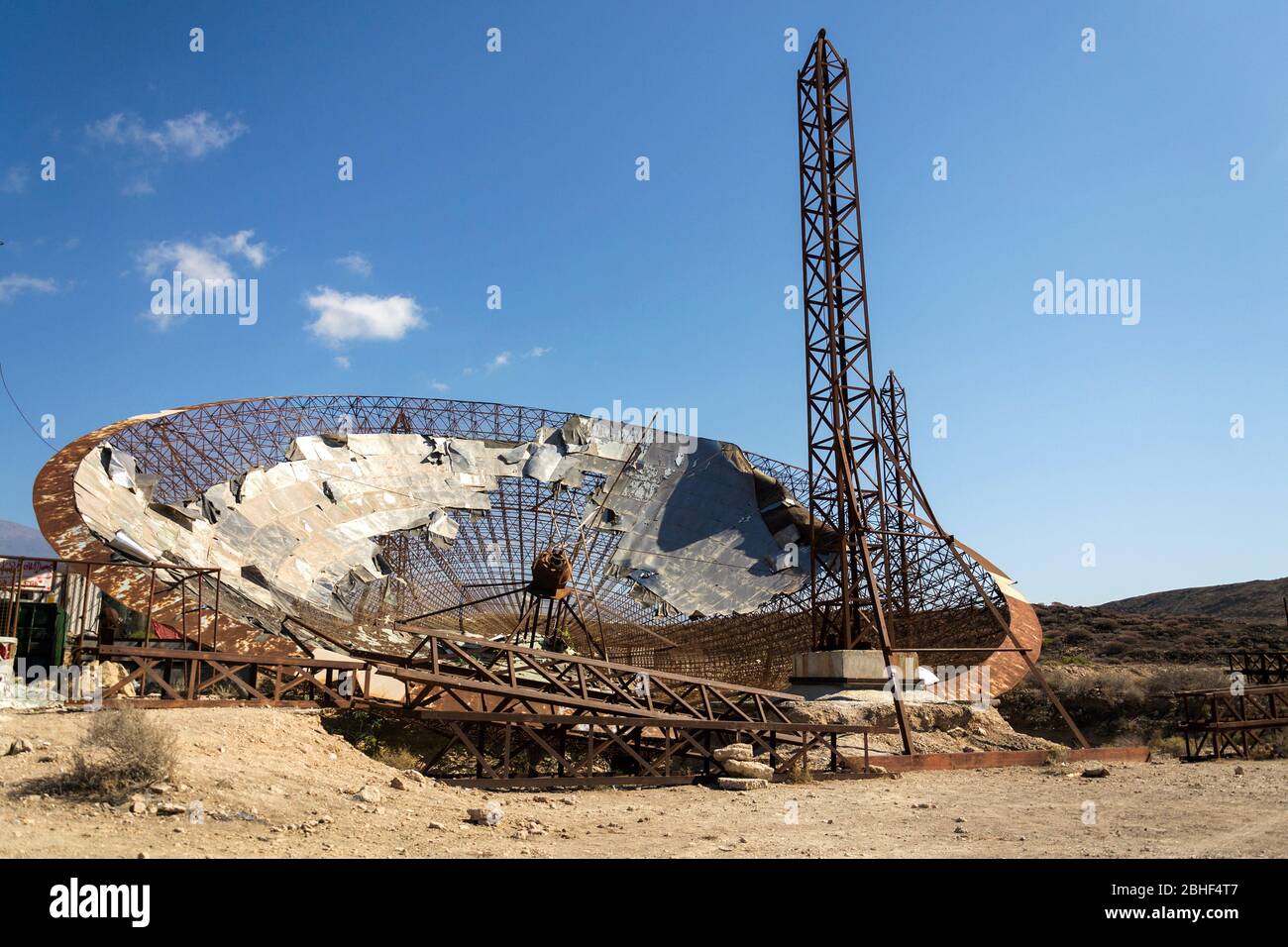 Old satellite dish antenna in dry arid land near El Medano, Tenerife, Canary Islands, Spain, telecommunication and wireless communication security Stock Photo