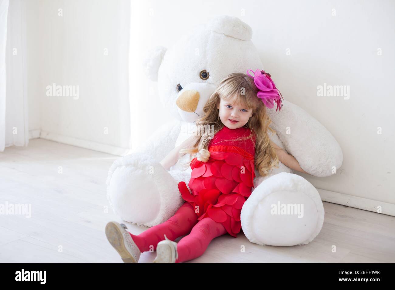 Beautiful little girl with toy big teddy bear Stock Photo - Alamy