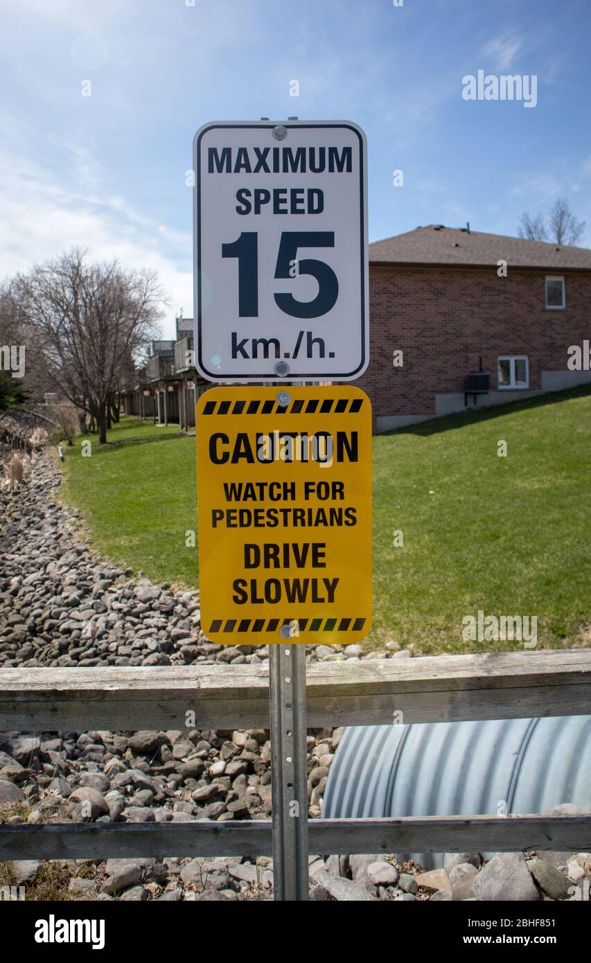 Residents area, signage: Maximum speed 15 km/ hour and Drive Slowly. Stock Photo