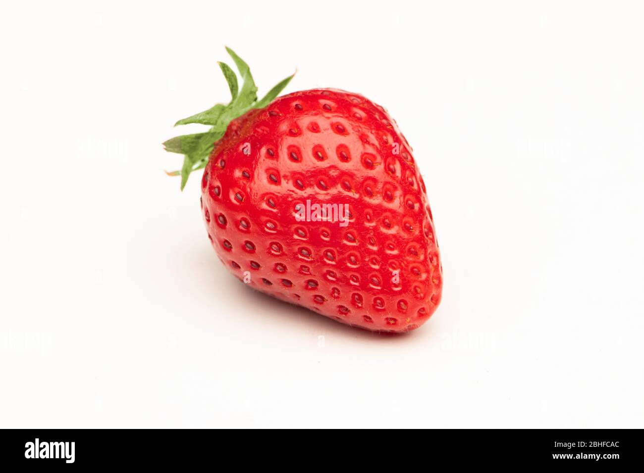 A single red strawberry isolated on a white background Stock Photo - Alamy