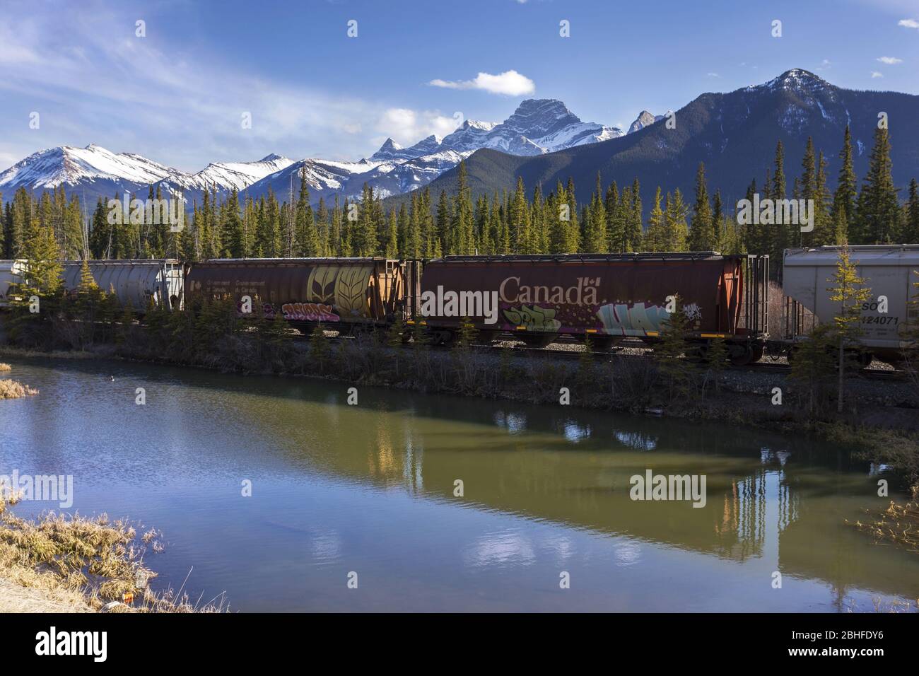 Canadian Pacific Freight Train Railway and Rocky Mountains Springtime Landscape in Bow Valley, Alberta Canada Stock Photo
