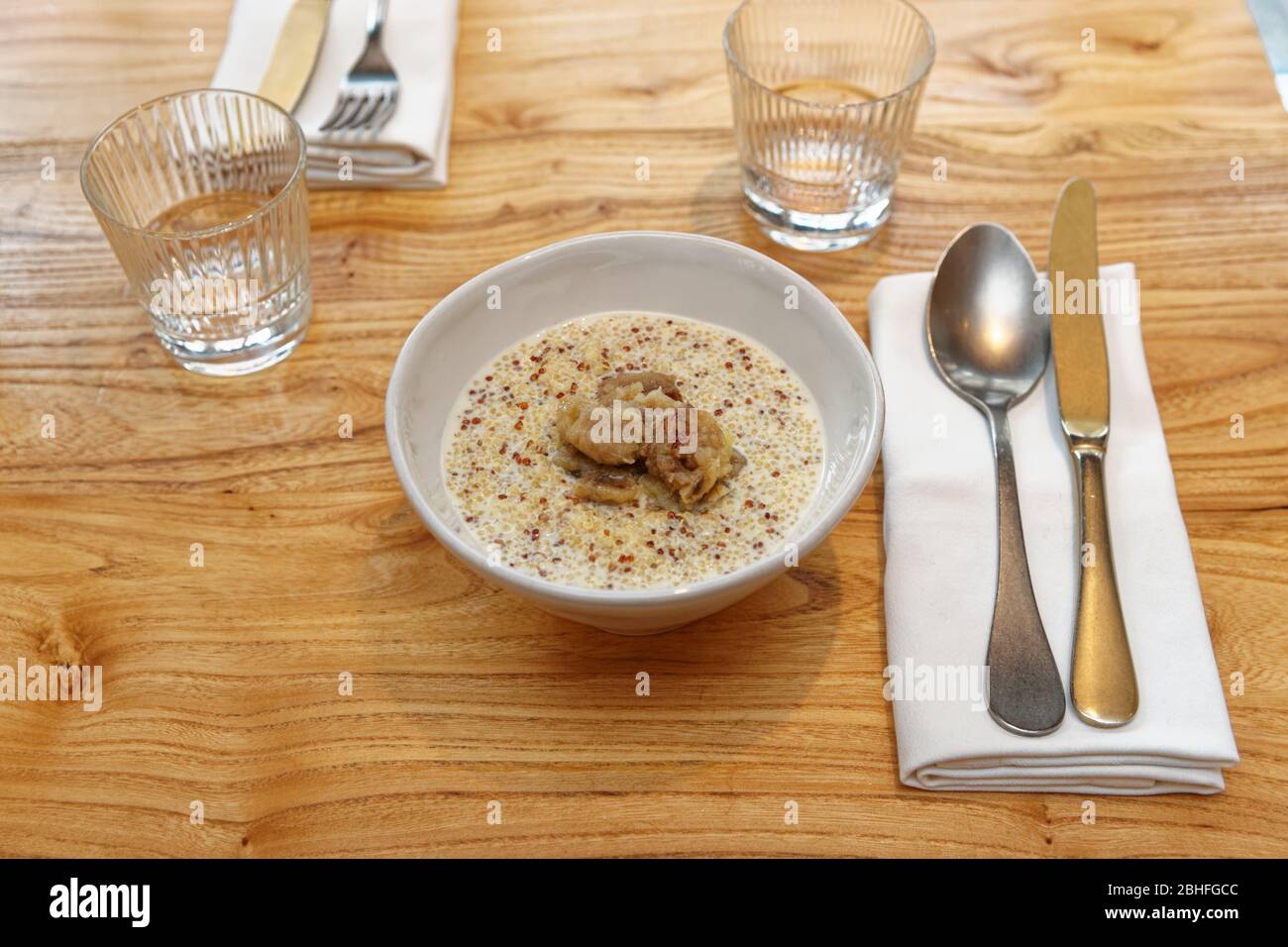 Quinoa cereal breakfast with cocoa milk and fried banana on restaurant table Stock Photo