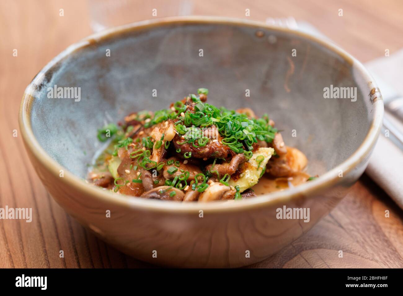 Fried mushrooms with soy sauce and scallions, Asian dish Stock Photo