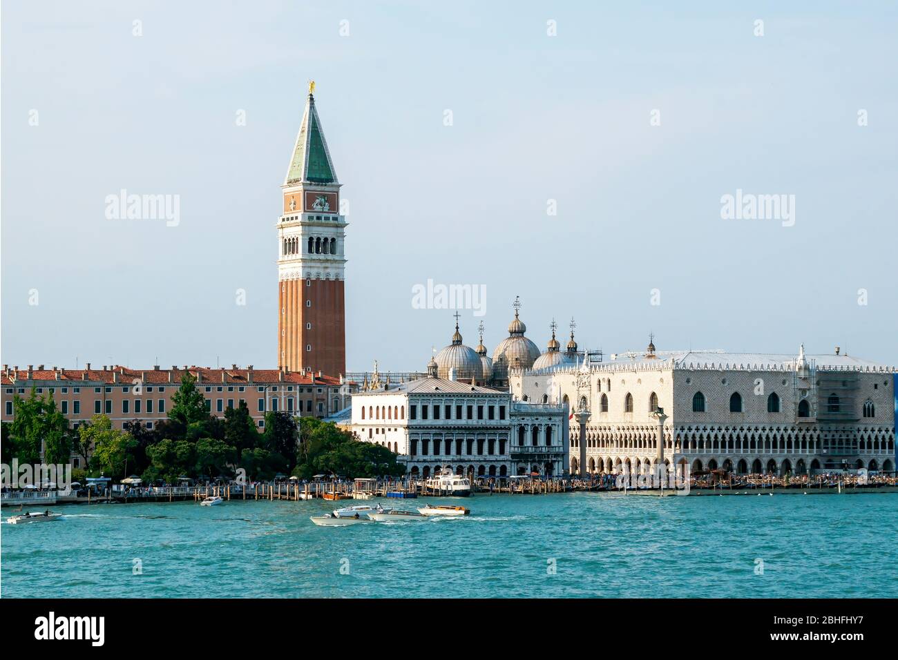 Crowds of people fill Piazza San Marco. Saint Mark's Square.  Campanile or bell tower of St Marks Cathedral on the left. As seen from the Grand Canal. Stock Photo