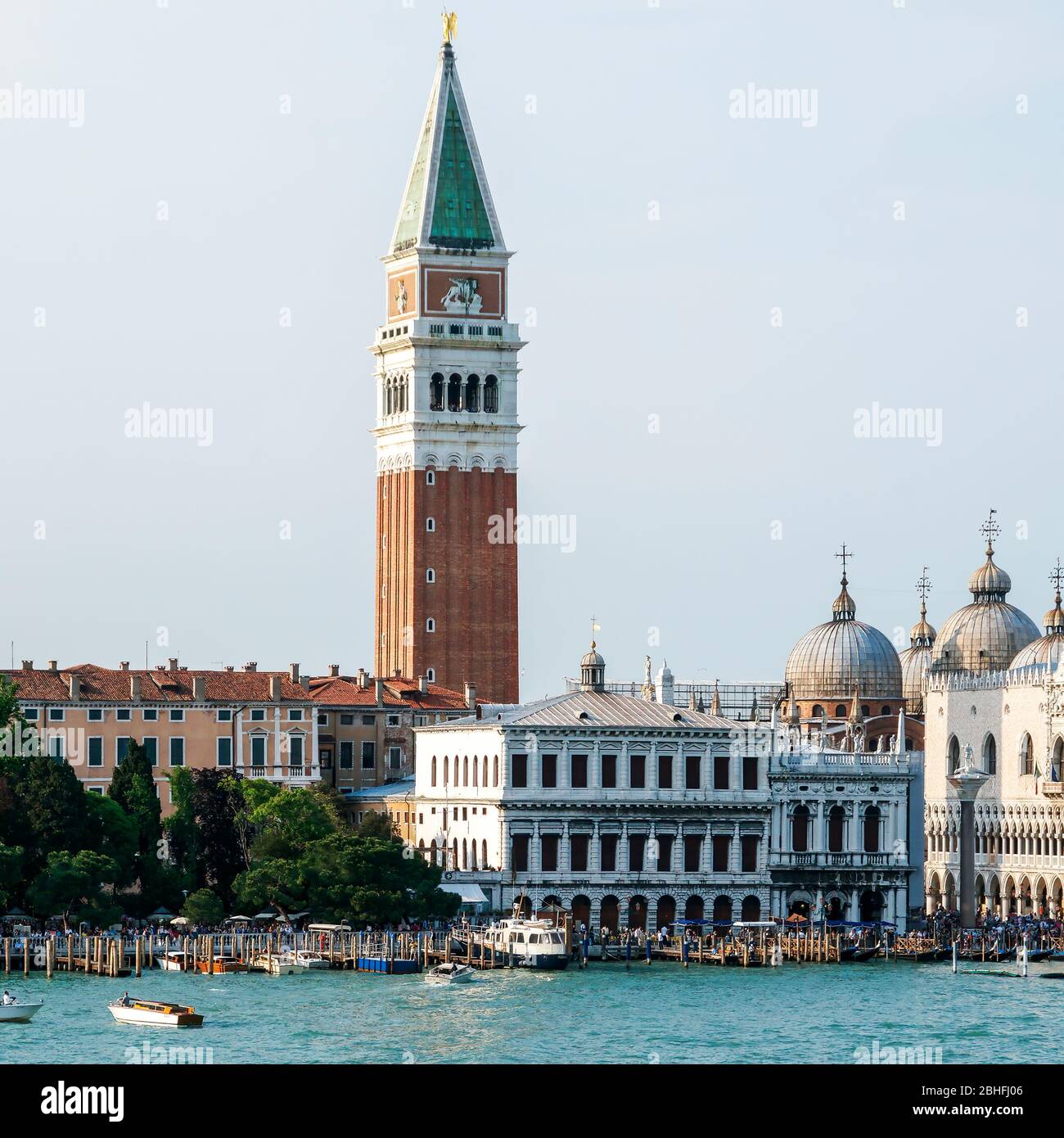 Campanile or bell tower of St Marks Cathedral, Piazza San Marco. Saint Mark's Square. People crowd the public dock area on the Grand Canal. Stock Photo