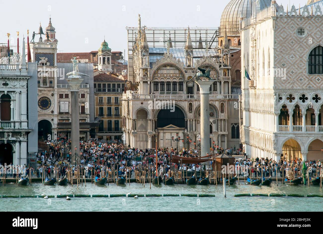 Crowds of people gather in Piazza San Marco. - Saint Mark's Square near the gondola docks on the Grand Canal. Venice, Italy. Late afternoon shadows. V Stock Photo