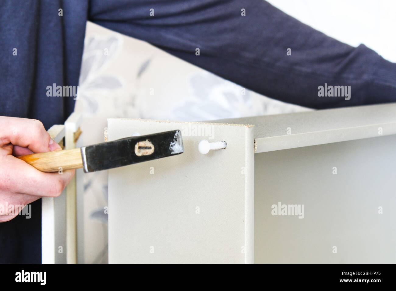 A man collects a drawer for a chest of drawers. DIY furniture assembly