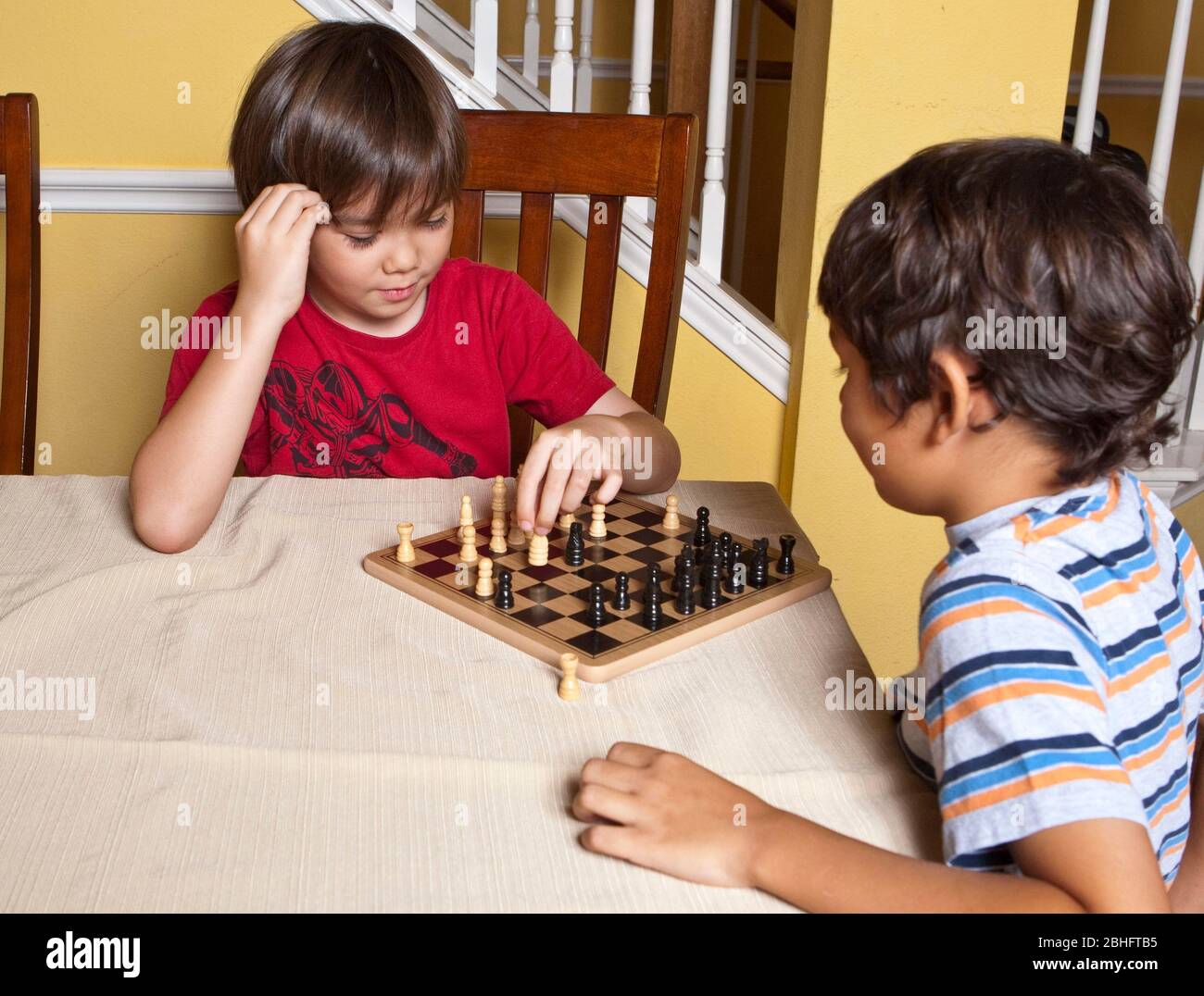 Austin Texas USA, 2012: *-year-old Mexican-American and Japanese-American  boys play game of chess while at home. ©Marjorie Kamys Cotera/Daemmrich  Photography Stock Photo - Alamy