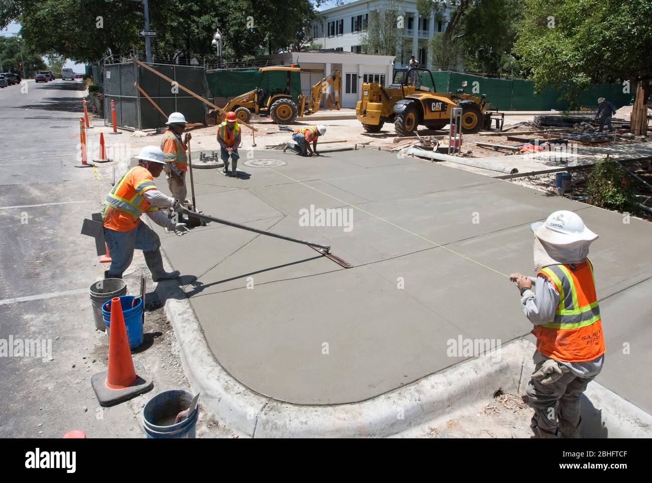 Austin Texas USA, 2012: Group of mostly Hispanic male workers complete concrete sidewalk in front of Texas Governor's Mansion in downtown Austin.  ©Marjorie Kamys Cotera/Daemmrich Photography Stock Photo