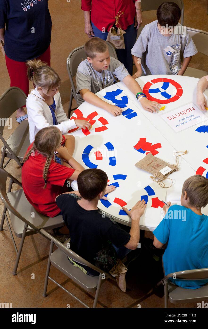 Georgetown Texas USA, August 17 2012: Children play game with American flag-colored red and blue cards at 'Vacation Liberty School' that teaches children ages 7-12 'the benefits of liberty from the perspective of faith, hope and charity', ideas championed by the USA's founding fathers when creating the Declaration of Independence, Bill of Rights and the Constitution. Although formed as a non-political program, it does advocate the Tea Party-like ideals of fiscal responsibility, free markets and limited government. The name is a take-off on vacation Bible school. ©Bob Daemmrich Stock Photo