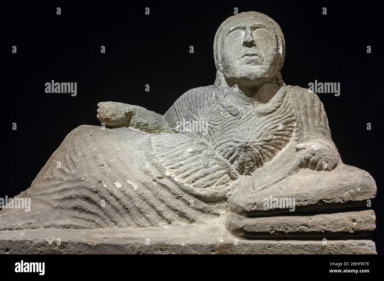 Barcelona, Spain - Dec 27th, 2019: Etruscan cineray urn on podium. Reclined female figure sculpted Stock Photo
