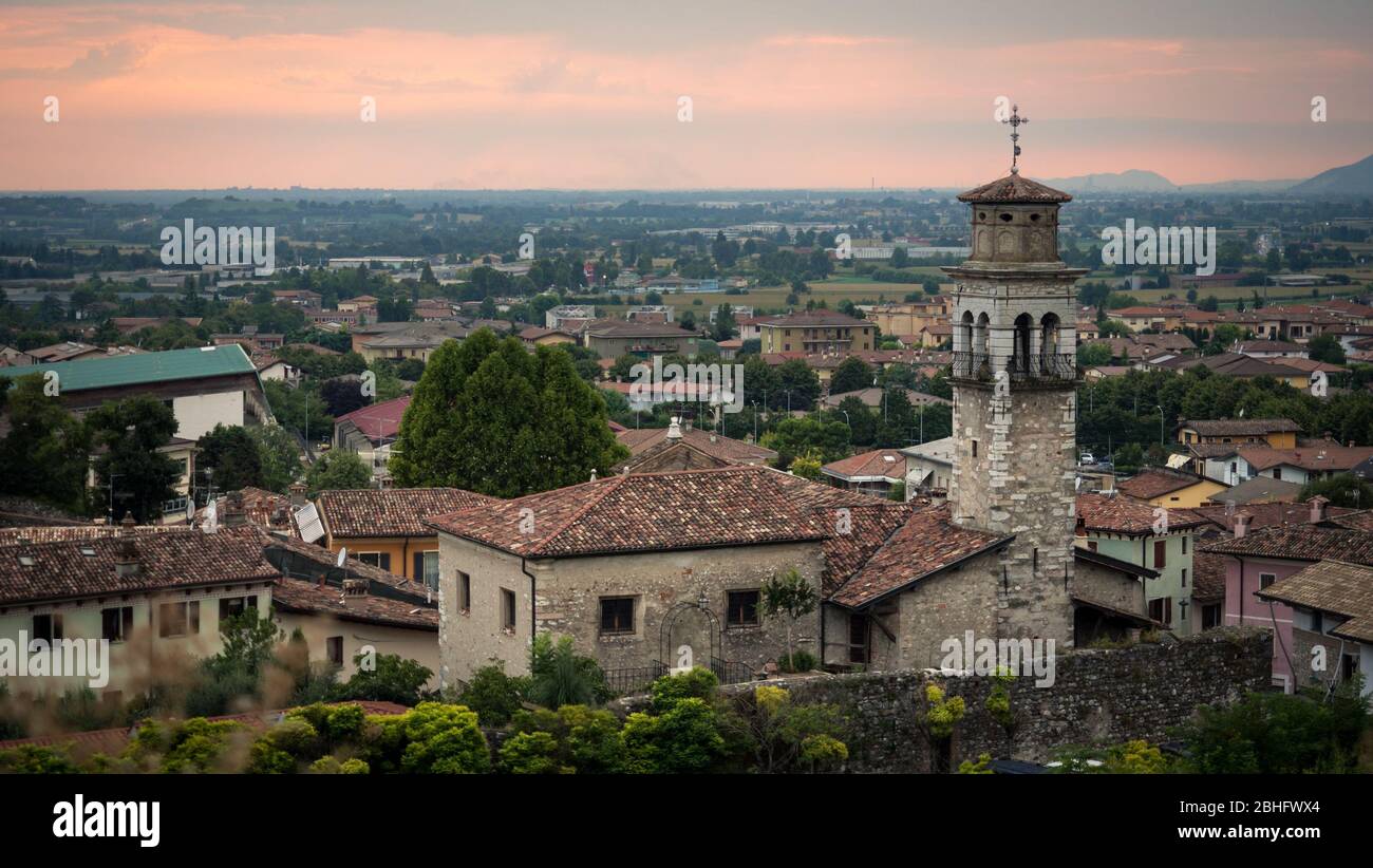 View of the town of Lonato at sunset. In the foreground an ancient bell tower. Stock Photo