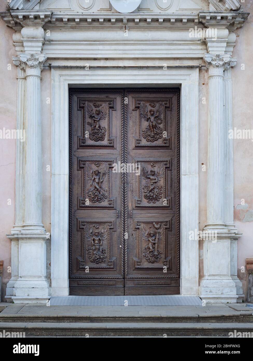 Carved wooden portal with scenes of saints from an ancient Italian church. Stock Photo