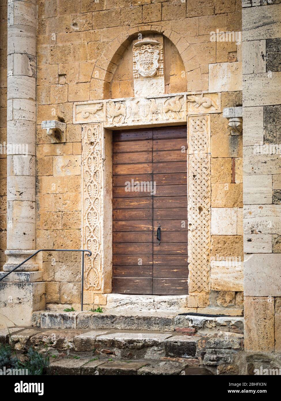 Detail of the carved stone entrance of an ancient Italian medieval church. Stock Photo