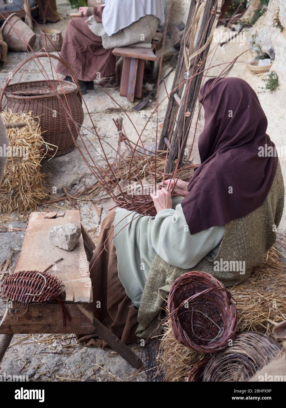 Woman weaves baskets by hand in a rural area market. Stock Photo