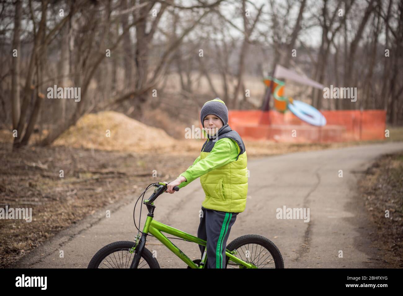 Child on a bicycle on a cloudy day looking at the camera Stock Photo