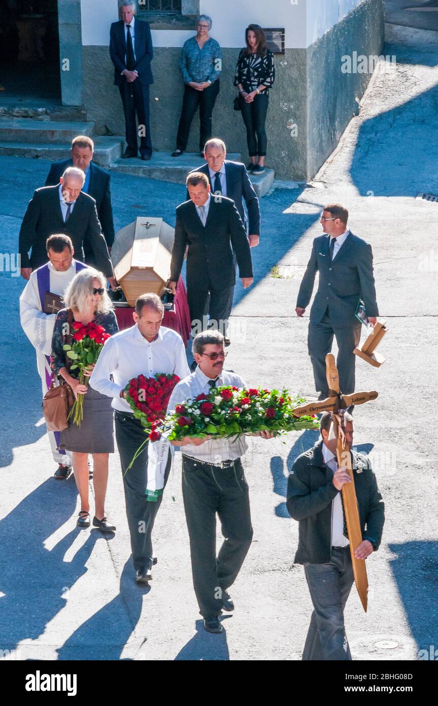 Funeral procession departing a Catholic chapel in an alpine village in the remote Lotschental valley, Valais, Switzerland Stock Photo