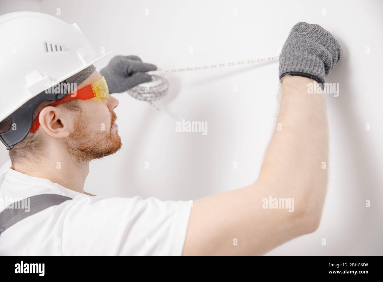 Electrician installing mounting tape LED strip light decorative lighting Stock Photo