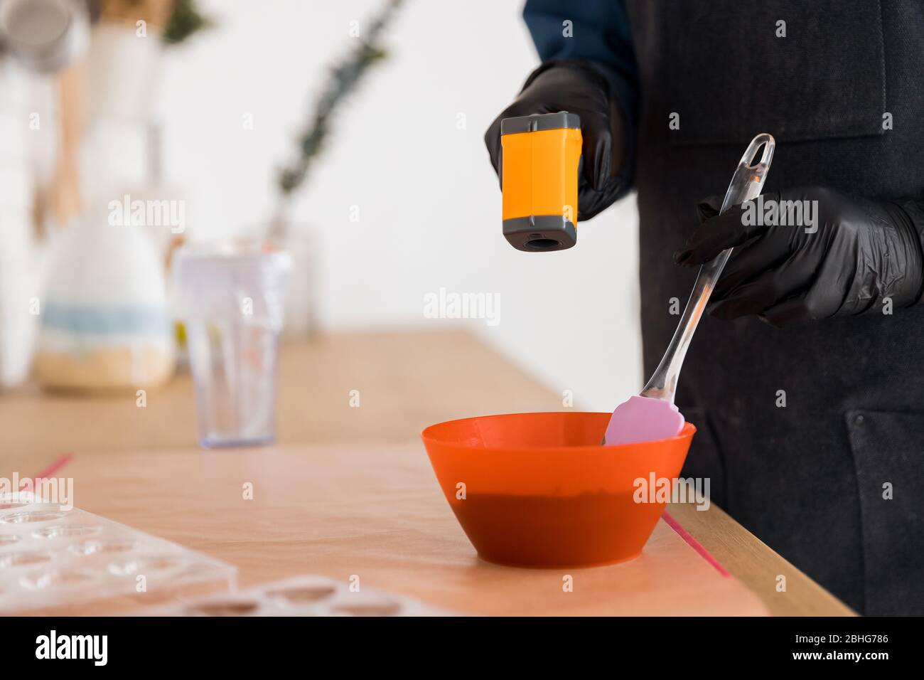 Measuring the temperature of chocolate in a bowl. Special infrared  thermometer. Close-up Stock Photo - Alamy