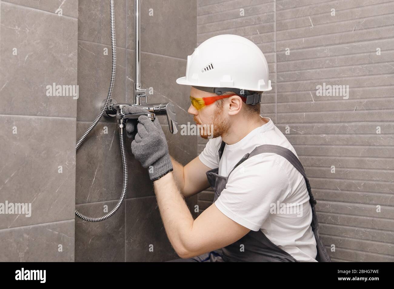 Plumber installing shower stall, work in bathroom Stock Photo Alamy