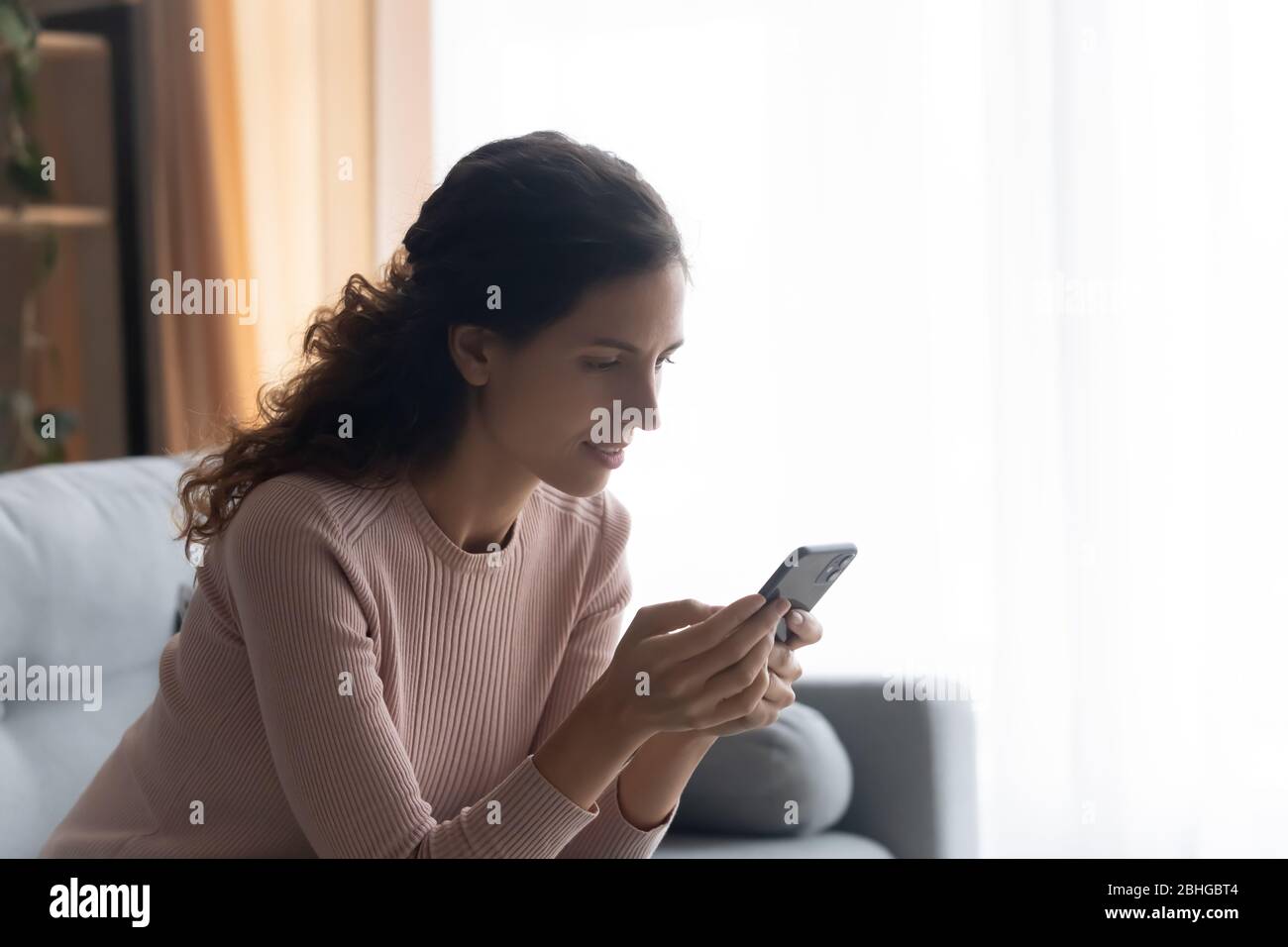 Pretty young woman involved in pleasant conversation online. Stock Photo