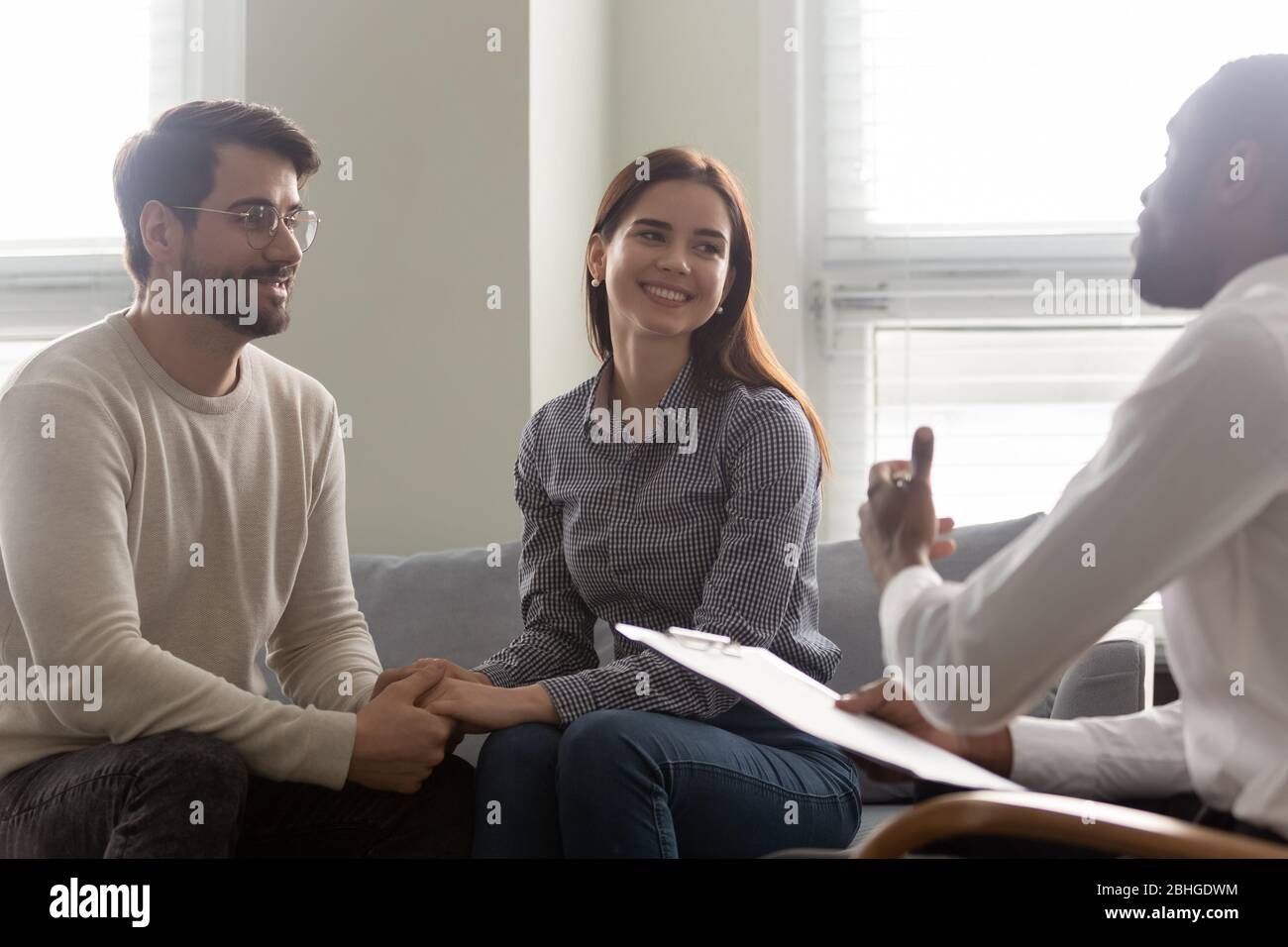 Happy couple, man and woman at reception with family therapist. Stock Photo