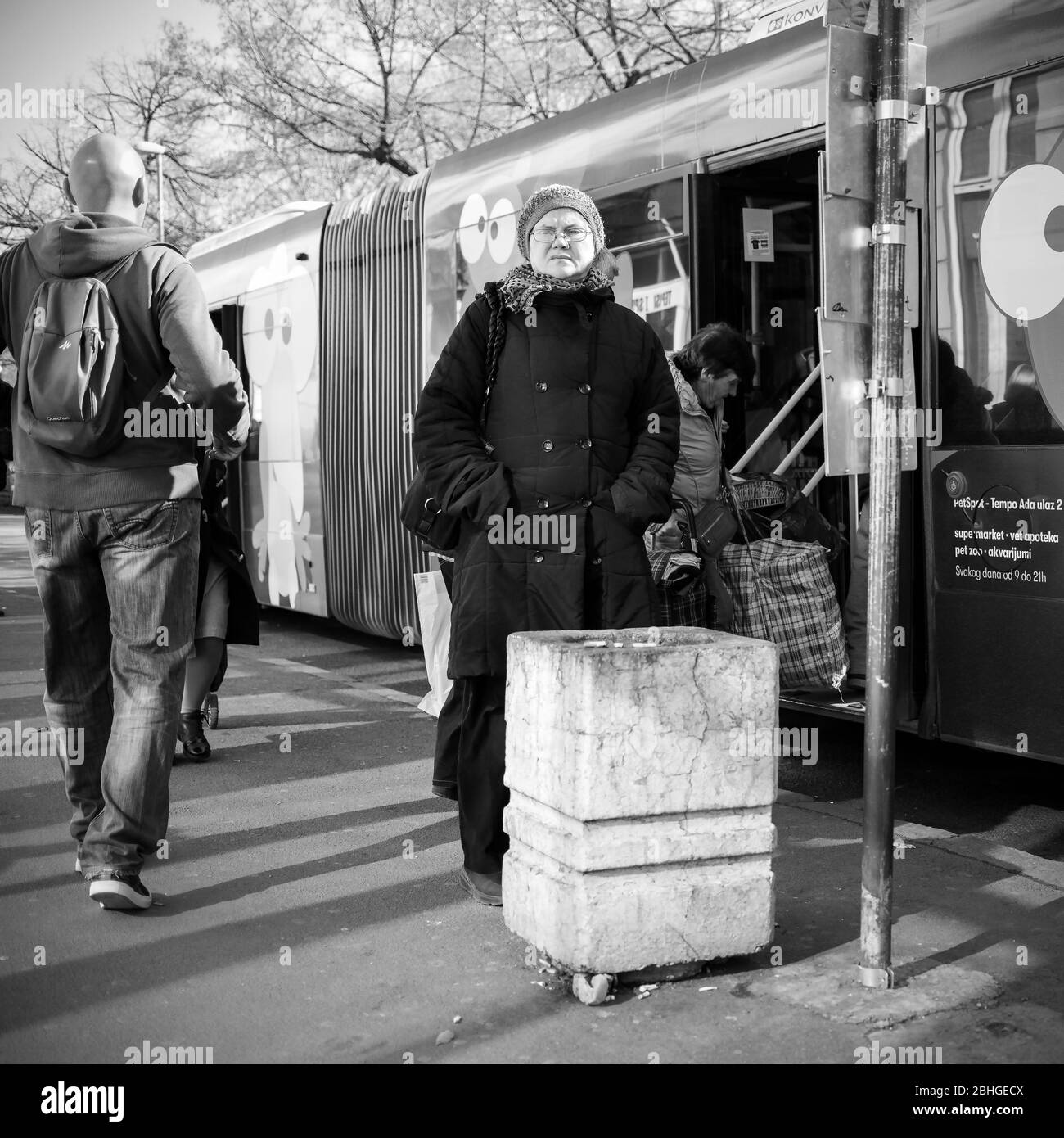 Belgrade, Serbia, Feb 22, 2020: Public transport bus and passengers at bus stop in Zemun (B/W) Stock Photo