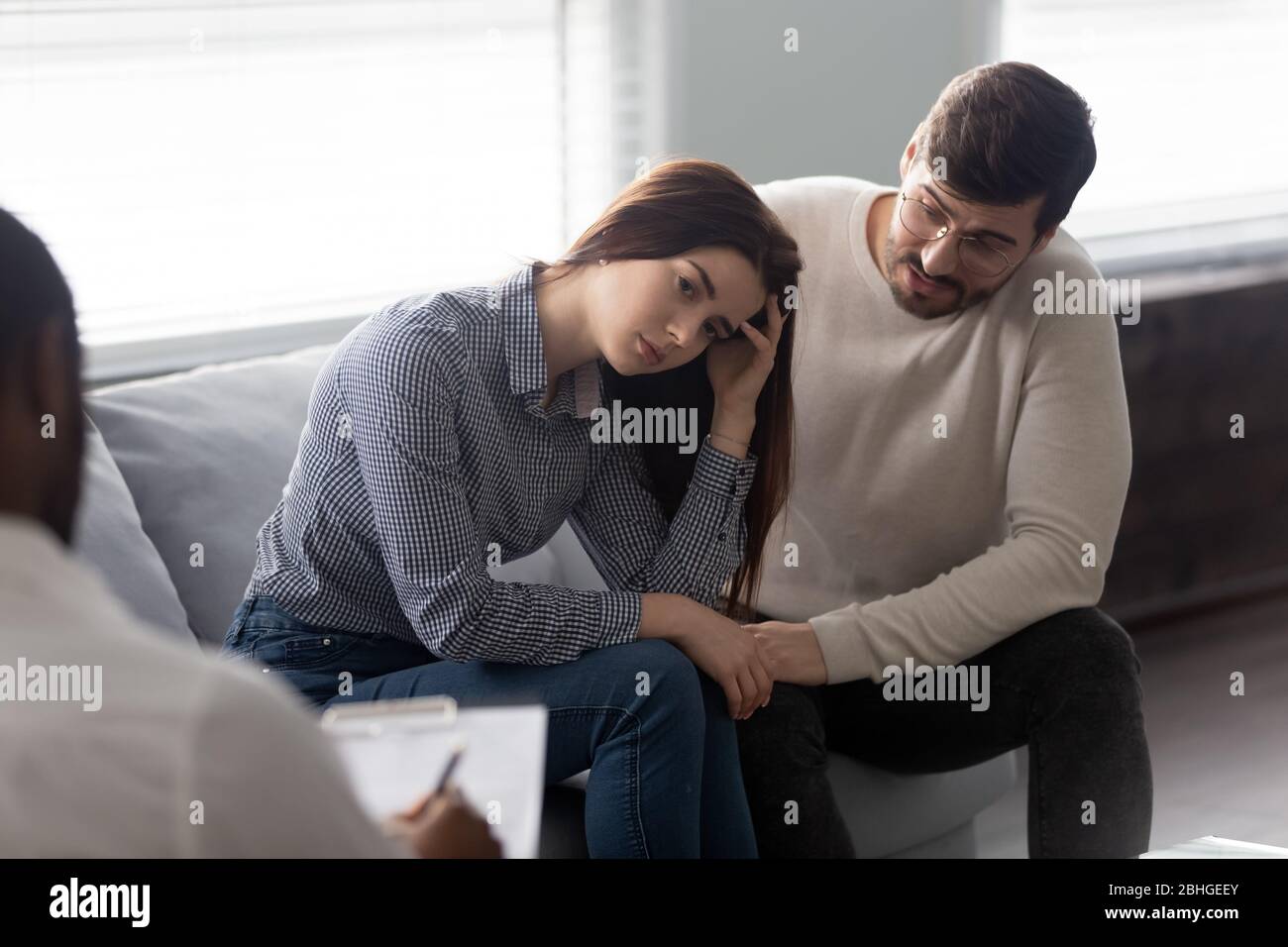 Disappointed man and woman at reception with family therapist. Stock Photo
