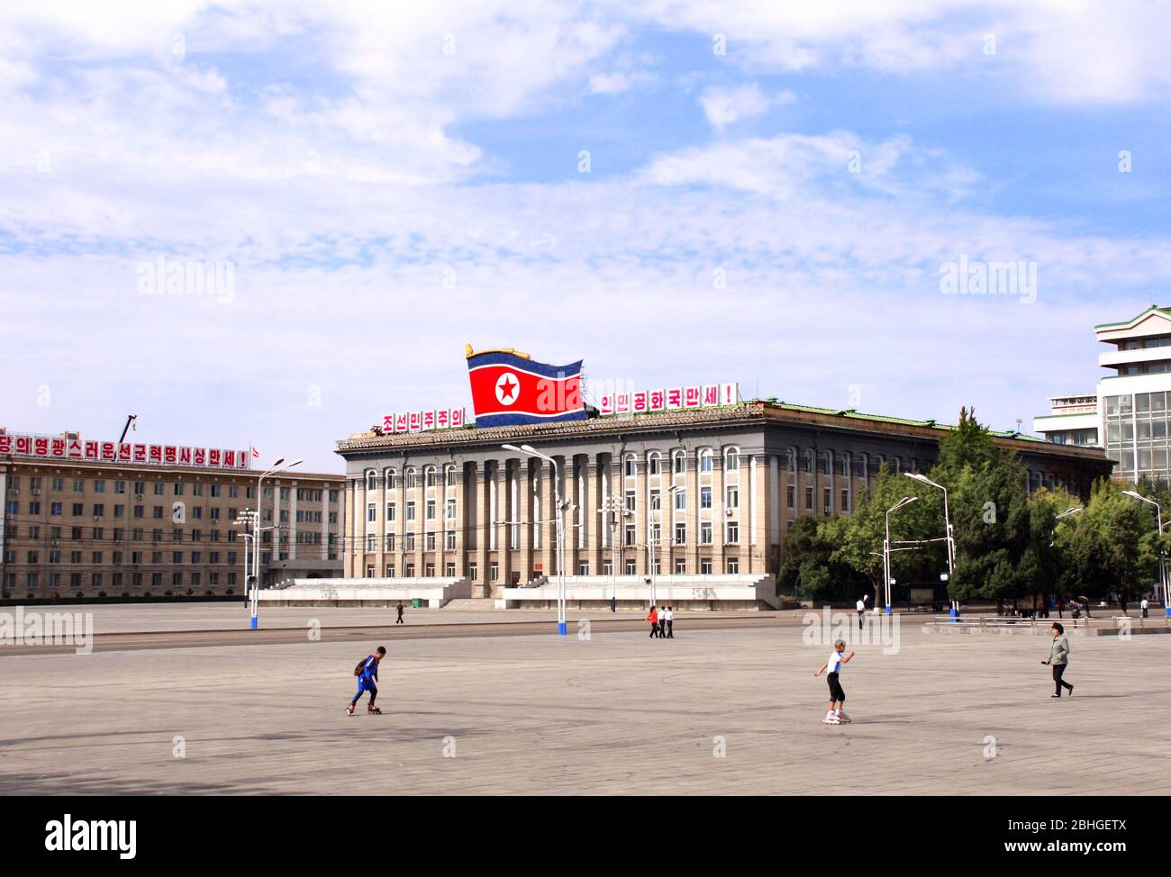NORTH KOREA, PYONGYANG - SEPTEMBER 26, 2017: Boys ride rollerblading in Kim Il Sung Square near to building of Ministry of Foreign Trade of the DPRK, Stock Photo
