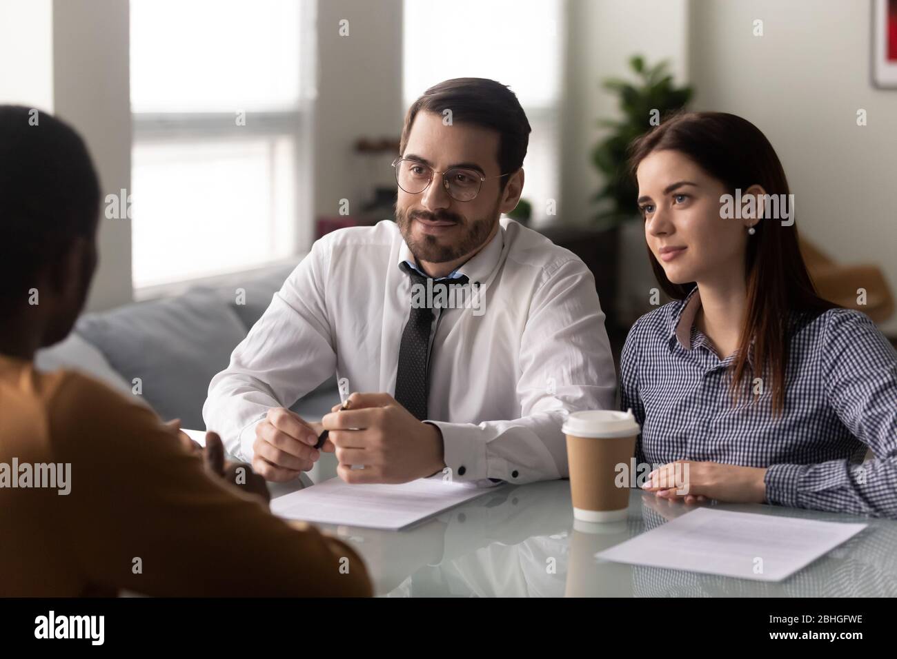 Businessman and businesswoman recruiters listen candidate at job interview. Stock Photo