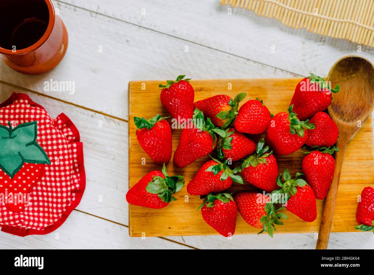 Organic strawberries on a cutting board fruit on a white wooden table Stock Photo