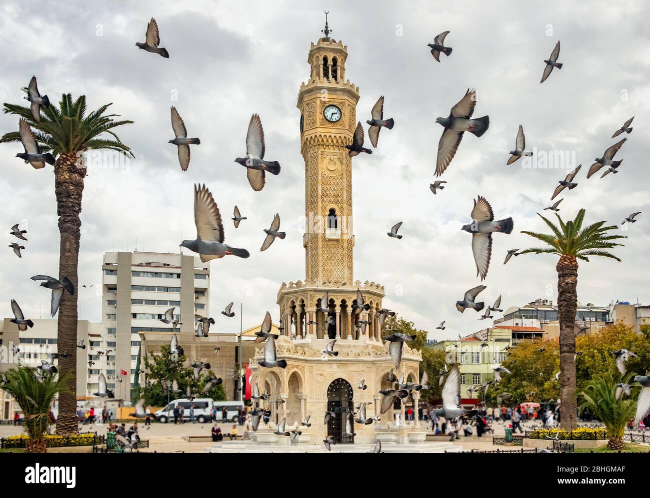Flock of pigeons flying around the Izmir Clock Tower in Izmir, Turkey. Stock Photo