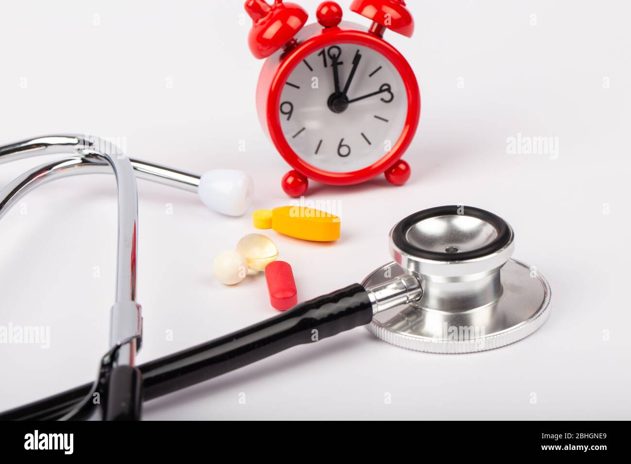 A picture of stethoscope, medicines and clock. It is for medical reminder. Stock Photo