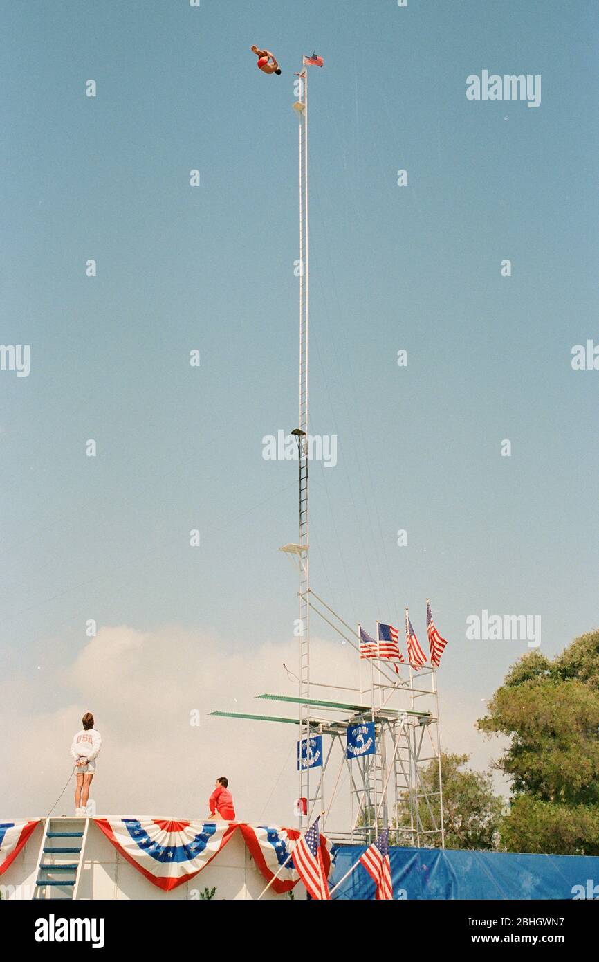 Springboard divers jumping from great heights into a small pool during