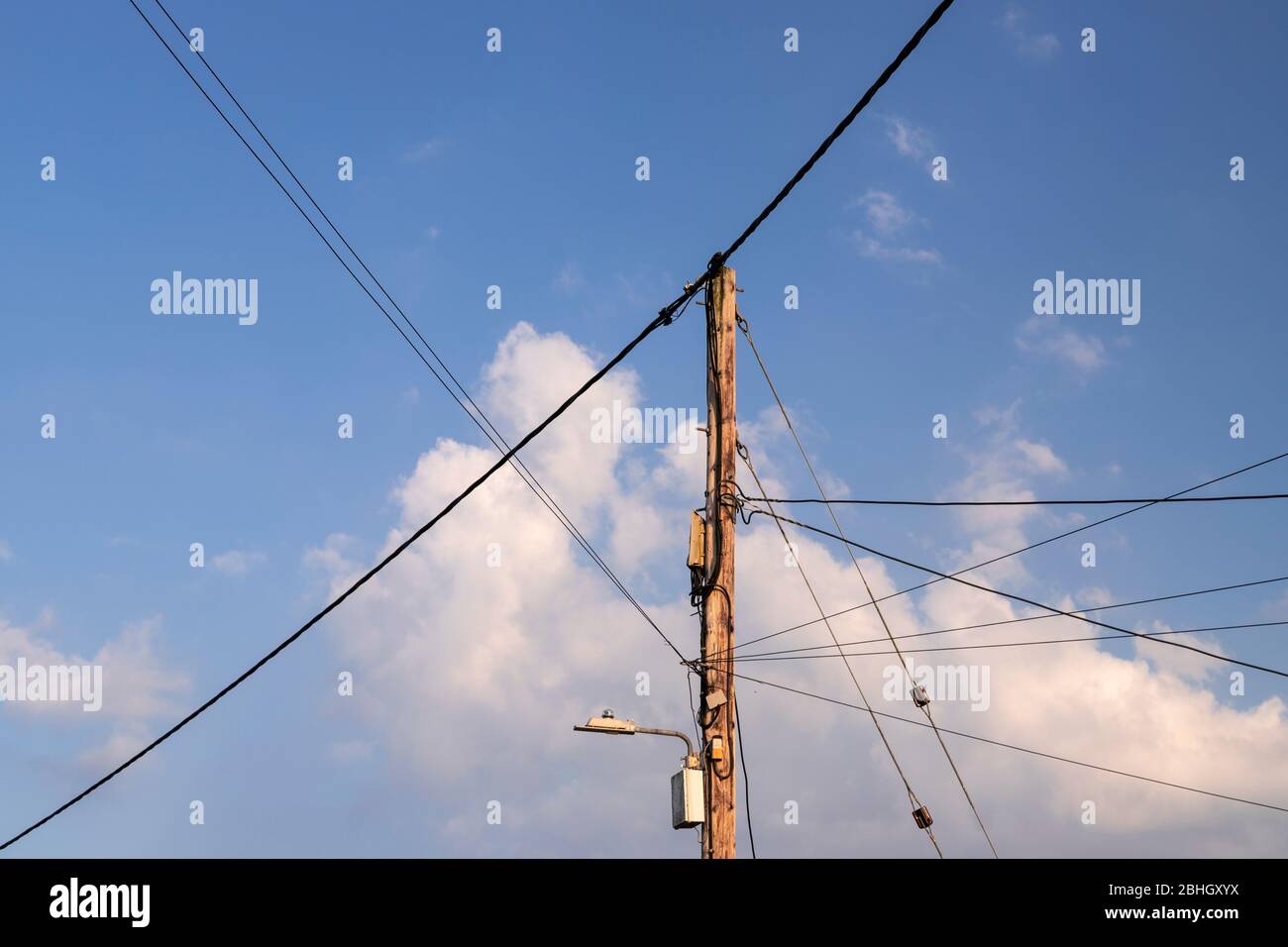 Wooden telegraph pole with power and telecoms cables attached Stock Photo