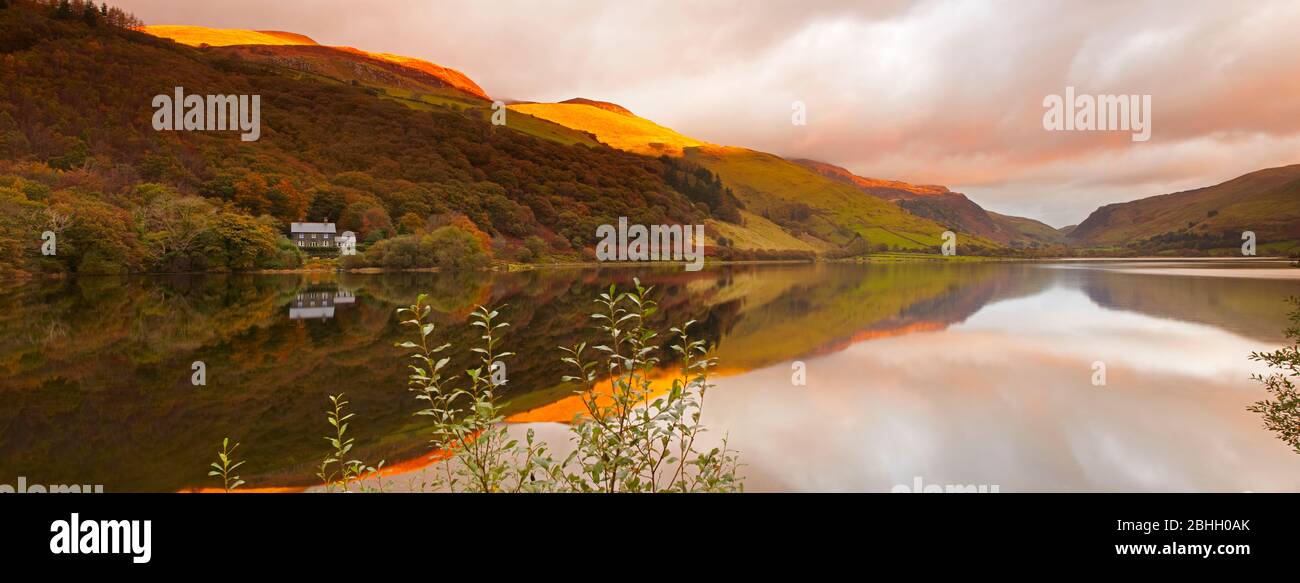 Dawn light touching the tops of Cadair Idris above Tal Y Llyn lake in Snowdonia national park. Stock Photo