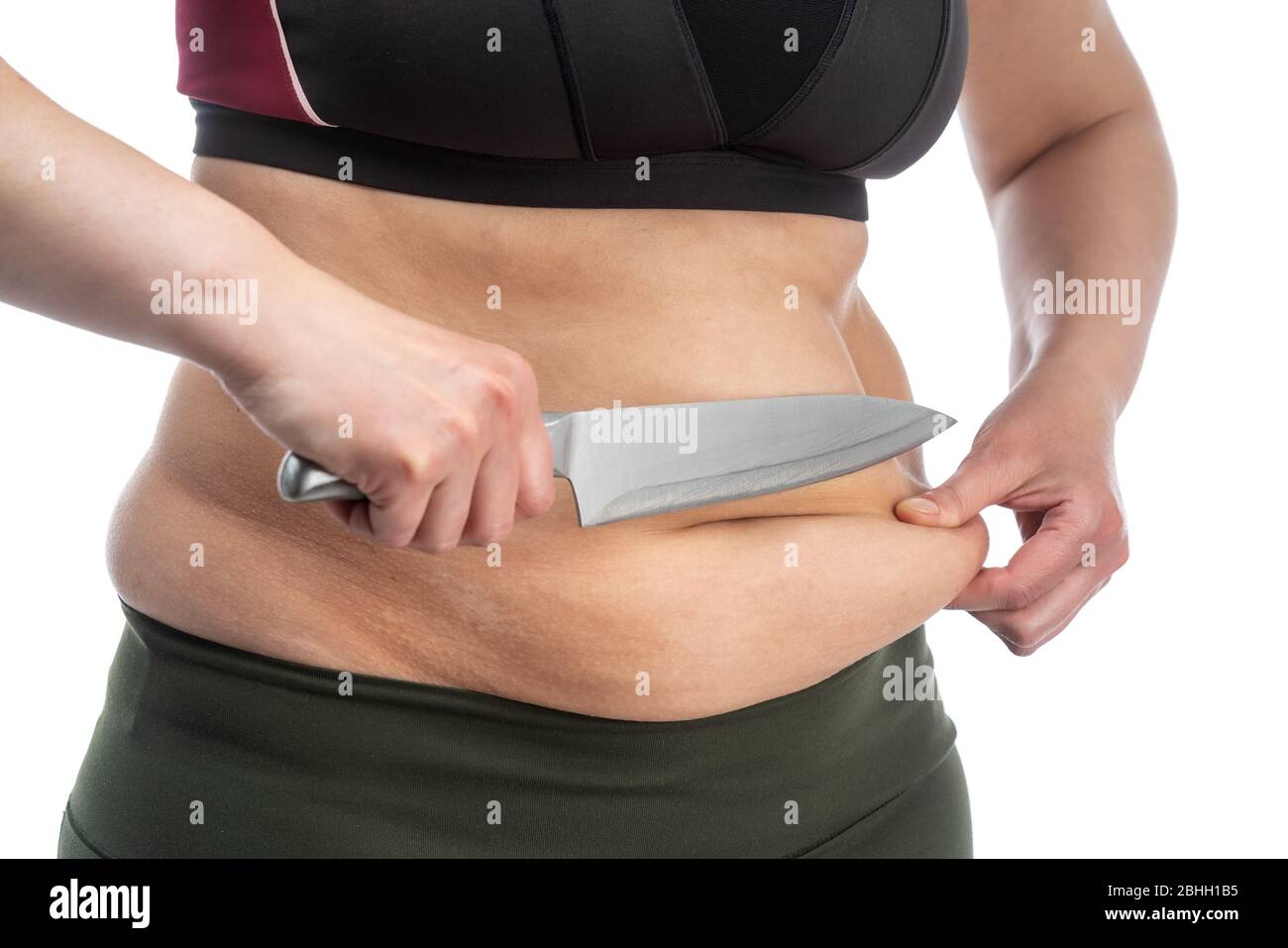 Middle-aged woman with obesity and saggy skin of the abdomen, on a white background, close-up. Knife, a symbol of plastic surgery. Stock Photo