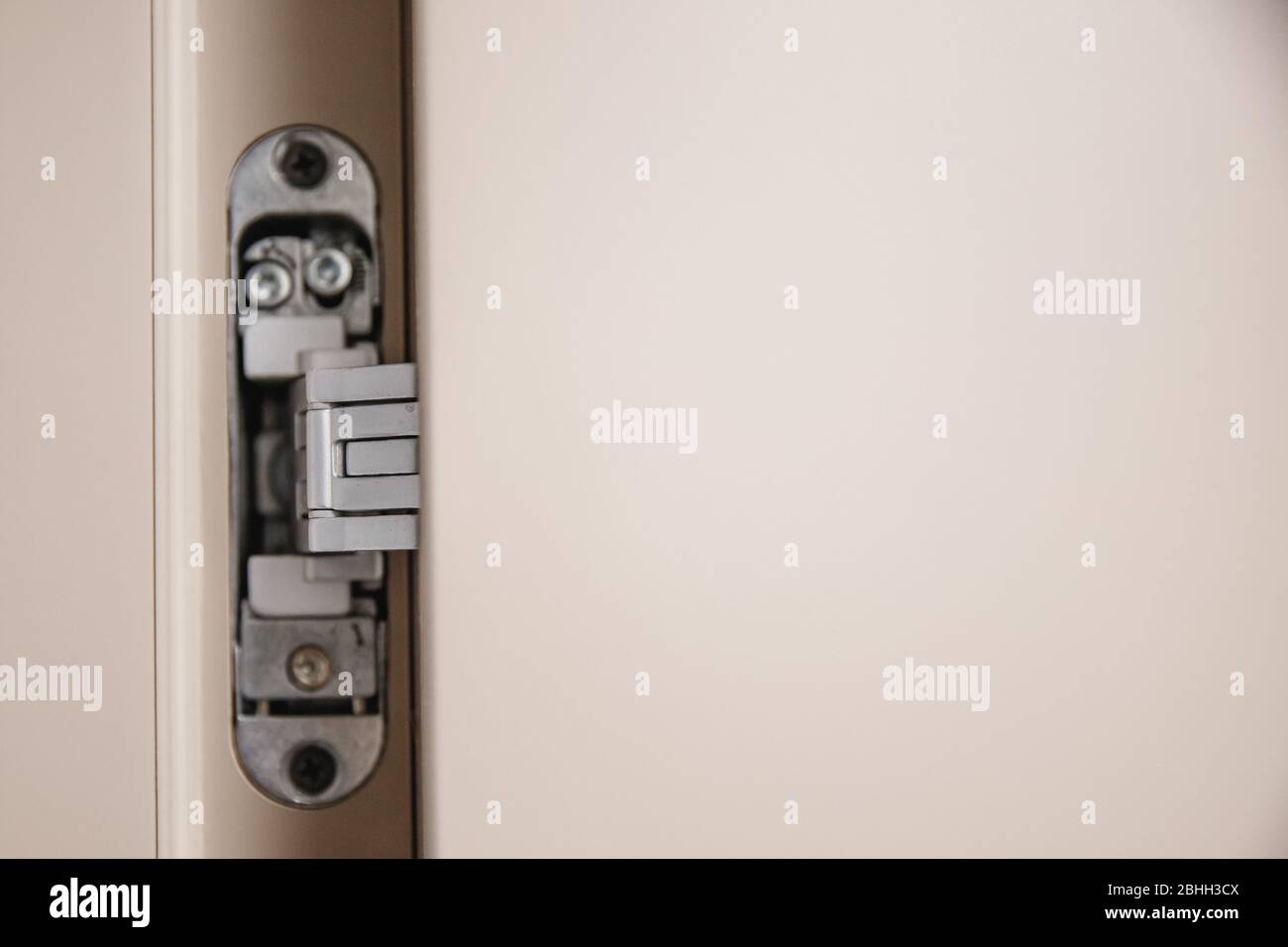 Flushmounted metal door hinges hidden embedded in wooden canvas Stock