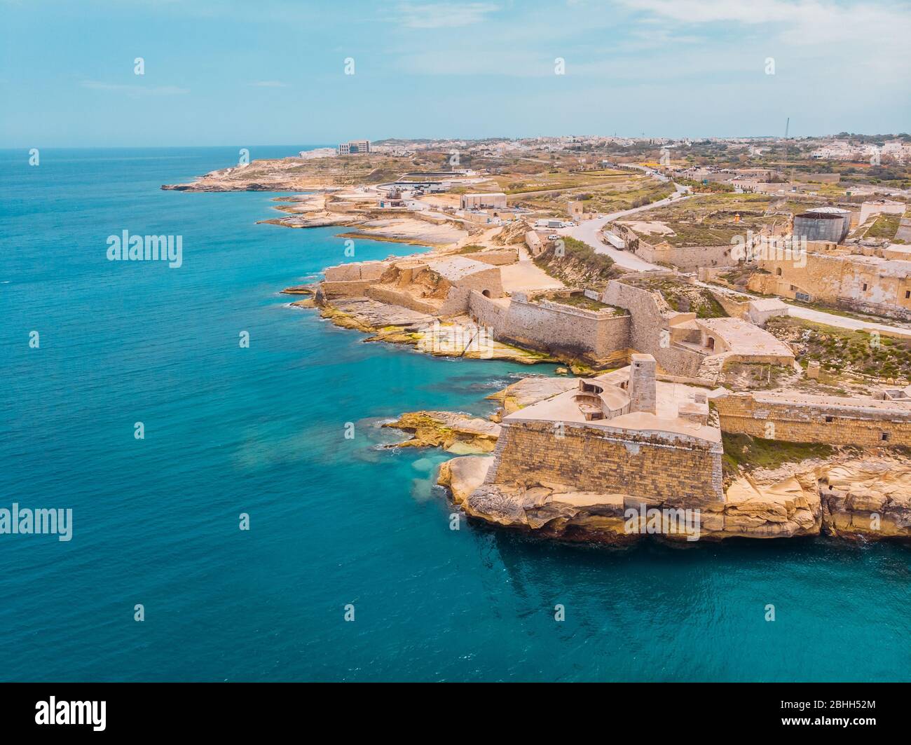 Ancient stone military fort Malta island made of brick rocks on shore blue sea with view city Valetta, aerial top view Stock Photo